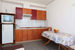 希洛Apartment in Silo/Insel Krk 13441的厨房配有桌子、电视和冰箱。