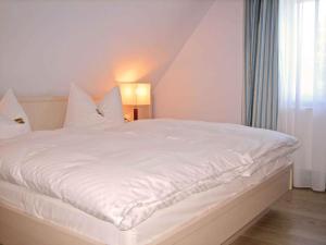 普雷罗Holiday home in Prerow (Ostseebad) 2650的窗户客房内的一张白色床
