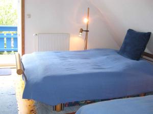 DändorfApartment in Dierhagen (Ostseebad) 2646的窗户客房内的一张蓝色的床