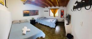 瓜塔佩Casa Roja Parche Campestre - Hospedaje Guatapé的一间卧室配有两张床和一张桌子