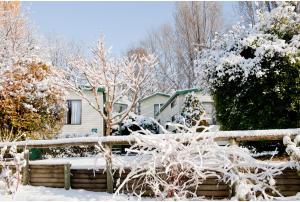金德拜恩Discovery Parks - Jindabyne的雪覆盖着栅栏的房子