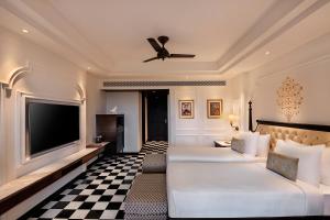 乌代浦Aurika, Udaipur - Luxury by Lemon Tree Hotels的酒店客房设有两张床和一台平面电视。