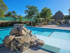曼萨尼约Hotel Parotas Manzanillo的毗邻度假酒店的带岩石的游泳池