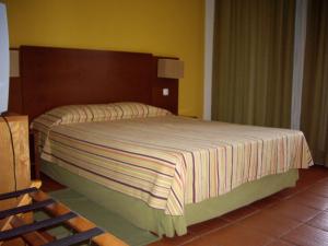 圣菲利佩Bamboo Xaguate Hotel的一间卧室配有一张大床和木制床头板