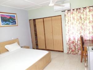 Oko SomboPANAASA GUEST HOUSE的一间卧室配有一张床、一张桌子和一个窗户。
