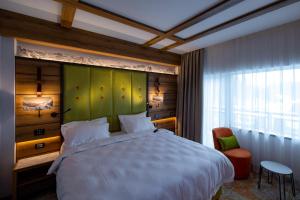 锡纳亚Hotel Belmont的一间卧室设有一张大床和绿色的墙壁