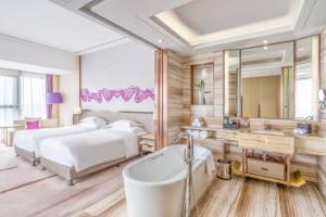 宜宾宜宾鲁能皇冠假日酒店的一间卧室设有两张床、浴缸和镜子