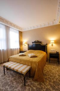 第聂伯罗阿克赛尔霍夫精品酒店的一间卧室配有一张大床,里面设有长凳