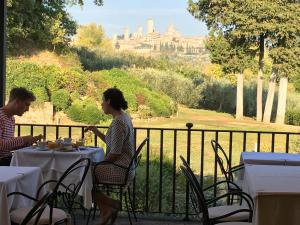 圣吉米纳诺Tenuta Guardastelle - Agriturismo and vineyard的坐在桌子旁的男人和女人