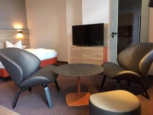 KratzeburgFamilienferienpark Dambeck的酒店客房配有一张床、两把椅子和一张桌子