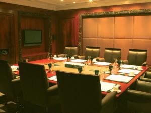 新德里克拉瑞芝新德里酒店的一间会议室,配有长桌子和椅子