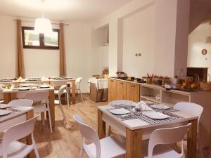 维贾内洛B&B Le Cinque Cime的一间大厨房,内设桌子和白色椅子