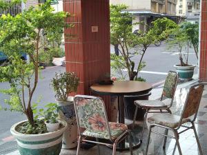 台南The LEY HOTEL 寶麗頌旅館的树木繁茂的庭院里设有桌椅