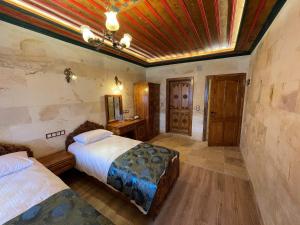 格雷梅优素福贝酒店的一间卧室设有两张床和木制天花板