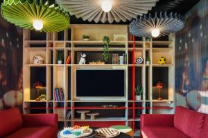 克拉马ibis Clamart Paris Velizy的一间带电视和2把红色椅子的客厅