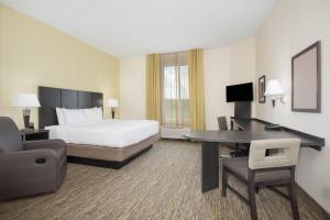 朗蒙特Candlewood Suites Longmont - Boulder Area, an IHG Hotel的配有一张床和一张书桌的酒店客房