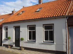 赫鲁德Spacious holiday home in Groede的白色房子,有橙色屋顶