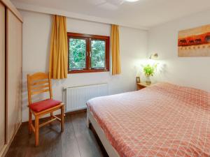 Stegeren汇斯耶阿提度假屋的卧室配有床、椅子和窗户。