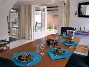 诺德克豪特Lovely Holiday Home in Noordwijkerhout near Lake的木桌,带食物和酒杯盘