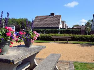 诺德克豪特Lovely Holiday Home in Noordwijkerhout near Lake的公园长凳上放着两瓶花