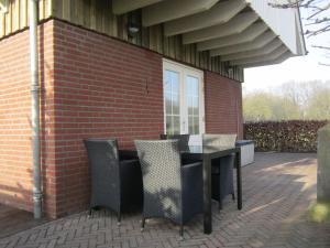 KnikkerdorpRural holiday home in Well with garden的砖砌建筑中带桌椅的庭院