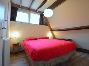 斯特兰普罗伊Cosy Holiday Home in Limburg with Forest nearby的一间卧室配有一张带红色床单的大床和窗户。