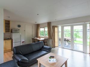 德布尔特Tidy chalet with dishwasher, surrounded by forest的客厅配有沙发和桌子