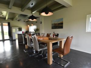 曲马勒姆Quaint Villa in Tzummarum with Garden Terrace的一间带木桌和椅子的用餐室