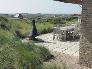 Midsland aan ZeeBeautiful villa on Terschelling in the dunes 150 meters away的一个带鸟浴的庭院里的桌椅