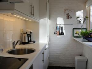 诺德克豪特Modern bungalow in South Holland的白色的厨房设有水槽和台面