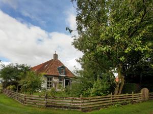 内斯Fairytale Cottage in Nes Friesland with garden的前面有围栏的房子