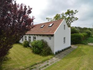 尼乌弗利特Nice holiday home on the Dutch coast with terrace的一间白色的小房子,有红色的屋顶
