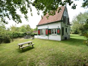 奥德多普Quintessential holiday home in Ouddorp with garden的小屋前面设有野餐桌