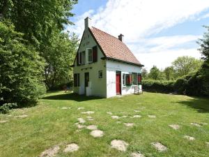 奥德多普Quintessential holiday home in Ouddorp with garden的院子中带红色门的小白色房子