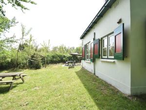 奥德多普Quintessential holiday home in Ouddorp with garden的旁边设有野餐桌和长凳的建筑