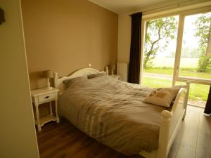 沃尔克姆Rural holiday home with a lovely sunny terrace的卧室配有白色的床和窗户。