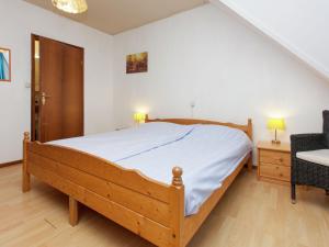 霍尔沃德Authentic holiday home in North Friesland的一间卧室配有一张大床和一把椅子
