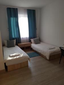 华沙Hostel Mleczna - Metro Zacisze的客房设有两张床和窗户。