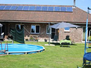 SpaubeekDreamy Holiday Home in Sweikhuizen的一座房子,里面设有一座带太阳能电池板的游泳池