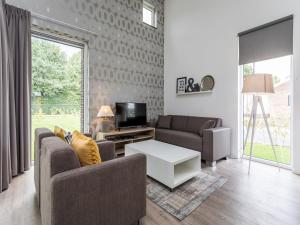 罗赫尔Modern and stylish villa with a covered terrace in Limburg的客厅配有两张沙发和一台电视机