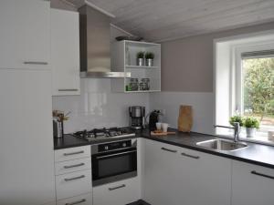 巴勒姆bungalow situated directly at a large sand dunes的厨房配有白色橱柜和水槽