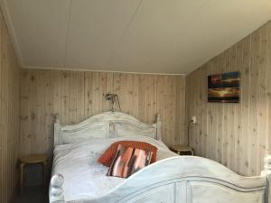 巴勒姆Secluded Holiday Home in Ballum Frisian Islands的配有木墙的客房内的一张白色床