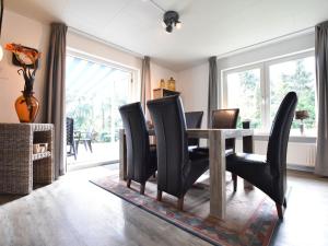 BeekdorpHoliday Home in Reutum Weerselo with Jacuzzi的一间带桌子和黑色椅子的用餐室