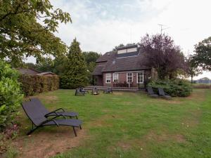 伦德Authentic Holiday Home in North Brabant by the Forest的房屋前方设有庭院和椅子