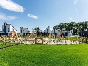 罗赫尔Tidy villa with a themed kids bedroom in Limburg的庭院内的游乐场,房屋位于后面