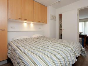 霍勒姆Apartment near the sea in Hollum的一间卧室配有一张床和木制橱柜