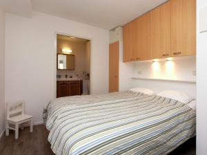 霍勒姆Apartment near the sea in Hollum的一间卧室配有一张床和一个小厨房