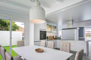 拉奥利瓦La Oliva Dreams luxury villa的厨房以及带白色桌椅的用餐室。