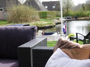 埃尔讷沃德Lush holiday home in Earnew ld的几张沙发坐在河边的庭院里