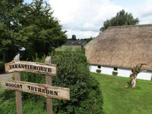 莱尔丹Quaint Farmhouse near River in Oosterwijk的茅草屋顶建筑前的街道标志
